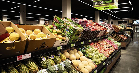 Fresh produce display at ALDI showcasing pineapples, melons, apples, and packaged vegetables under the ALDIfresh sign