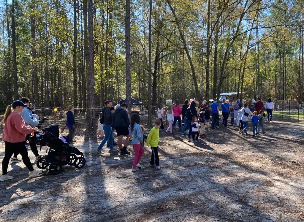 Families and children walking together at Healing Hooves Farm during a community tour in Clay County Florida