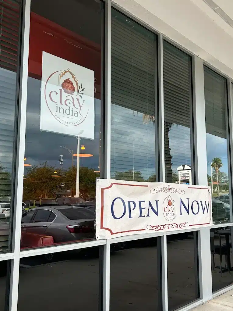 Open Now banner in the window of Clay India Indian restaurant on Blanding Boulevard in Orange Park