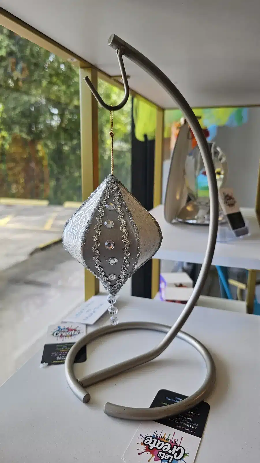Handmade hanging metal lantern craft on a stand at Let's Create Studios in Middleburg