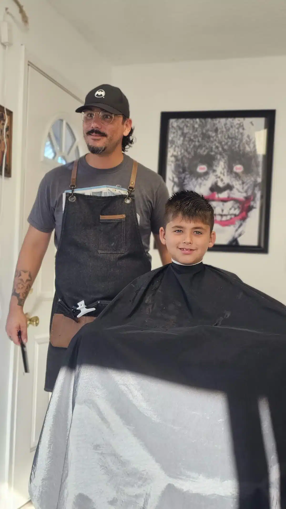 Jay the barber standing beside a smiling young client at Intermissions Barbershop in Green Cove Springs